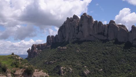 Lush-green-Montserrat-mountain-rock-ridge-aerial-dolly-right-across-impressive-Spanish-mountain-attraction