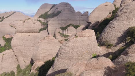 Drone-flying-between-rocks-of-Montserrat-massif-in-Catalonia,-Spain
