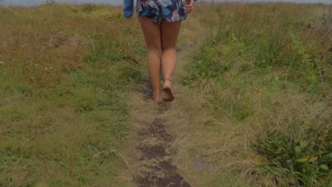 Caucasian-Woman-Spreading-Arms-While-Walking-At-Track-On-A-Windy-Day---Crescent-Head,-NSW,-Australia