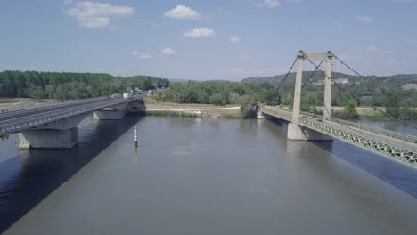 Elevated-aerial-view-between-Pont-de-Roquemaure-bridge-crossing-traffic-above-Rhone-river-France
