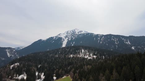 aerial-drone-shot-in-the-italian-alps,-flying-towards-a-mountain-with-snow-on-the-top