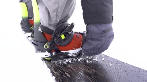 SLOWMO-snowboarder-does-up-binder-straps