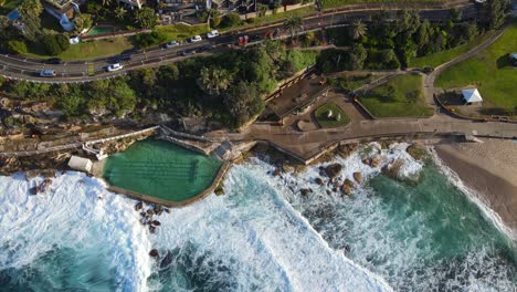 Aerial-View-Of-Bronte-Baths-With-Crashing-Waves---Public-Swimming-Pool-At-Bronte,-NSW,-Australia