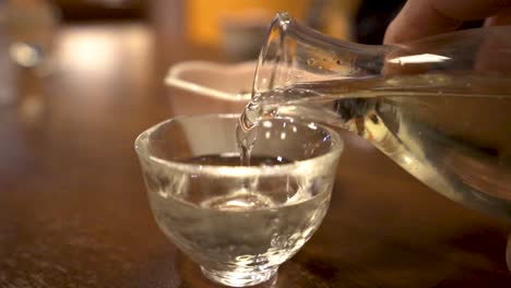 SLOWMO-close-up-of-man's-hand-pouring-sake-into-a-cup