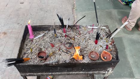Shot-of-the-fire-lightened-in-the-temple-with-dhoop-sticks-and-lamps-and-candles-on-the-place-for-lightening-the-lamps-for-god-in-temple-side