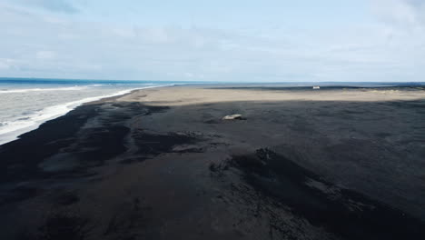 The-wreckage-of-an-old-wooden-boat-on-a-black-sand-beach-in-Iceland
