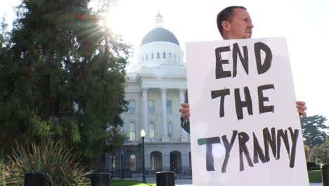 Male-Political-Protester-with-End-the-Tyranny-Sign