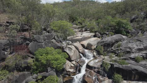 Aerial-shot-of-the-Waterfall-of-Davies-Creek-falling-over-the-rocks-in-the-Far-North-region-of-Queensland,-Australia---drone