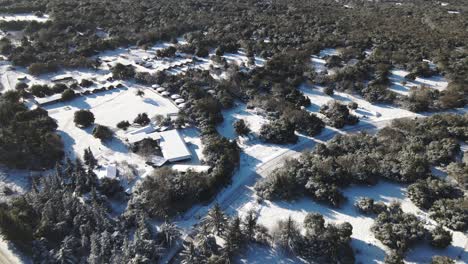 Aerial-drone-shot-of-Odem-Forest,-Golan-Heights,-Israel-with-snow-covered-floor-on-a-cold-winter-landscape-in-the-rural-landscape