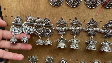 Hand-Eines-Mädchens,-Das-Handgefertigte-Ohrringe-Zum-Verkauf-Im-Shantiniketan-In-Westbengalen,-Indien,-Betrachtet