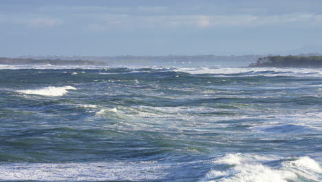 Zeitlupe-4k-Blaue-Ozeanwellen,-Die-Auf-Meer-Mit-Landspitze-Am-Horizont,-Australien,-Abstürzen