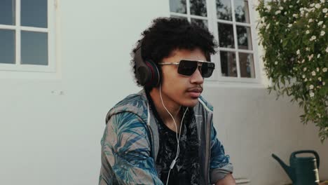 A-mixed-race-teen-boy-listens-to-music-with-sunglasses-on