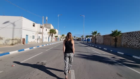 woman-walks-alone-on-a-deserted-road-in-the-city-of-Tarfaya-in-Morocco