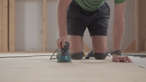 man-sanding-down-a-wooden-floor