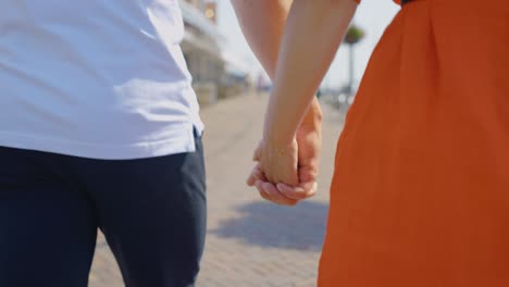 Couple-walking-and-holding-hands,-slow-motion-close-up