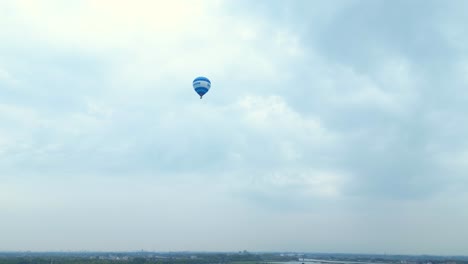 Looking-Up-At-Blue-Hot-Air-Balloon-Flying-Across-Hendrik-ido-Ambacht-Under-Clouds