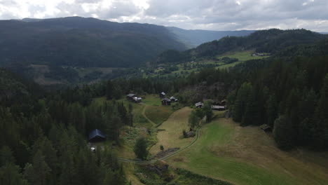 Aerial-shot-of-small-residential-houses-situated-in-the-valley-of-Telemark-Norway