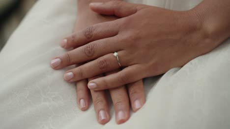 Bride-shows-off-wedding-ring-crossed-hands