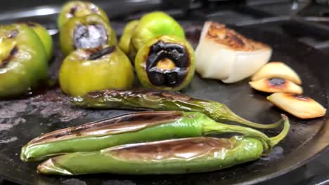 Close-Up-View-Of-Roasted-And-Charred-Green-Peppers,-Tomatoes-And-Onions-On-Tray