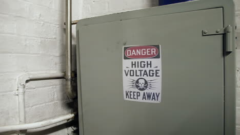 A-danger-warning-sign-on-a-high-voltage-electrical-breaker-box-in-an-industrial-building