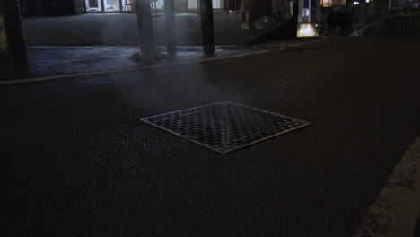 Heat-from-hot-spring-water-rises-up-out-of-a-square-metal-manhole-and-turns-into-steam-when-it-meets-the-cooler-temperatures-of-the-air