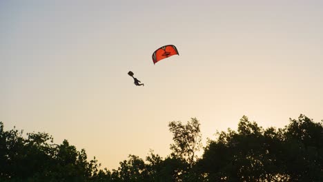 Epische-Luftbewegung,-Wenn-Der-Kitesurfer-Mit-Einem-Großen-Sprung-Startet---Schöner-Kontrast-Zum-Gelben-Sonnenuntergangshimmel
