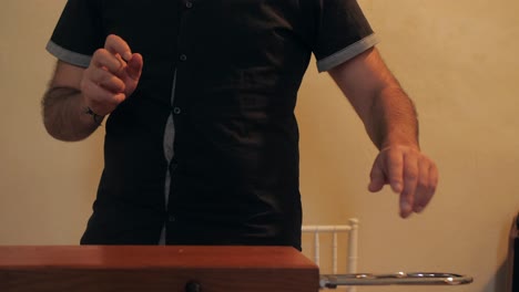 Musician-playing-unusual-theremin-instrument-indoors-using-hand-gestures,-slowmotion