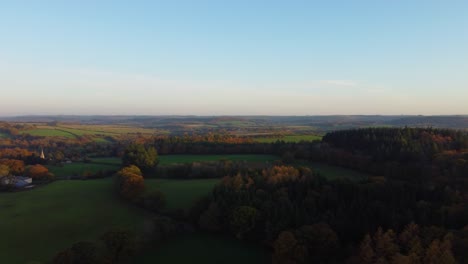 Unglaubliche-Luftaufnahme-Der-Britischen-Landschaft-Im-Sonnenuntergangslicht-Der-Goldenen-Stunde-Mit-Rollenden-Feldern-Und-Wald---Drohnenaufnahme-In-Dorset-Uk-4k