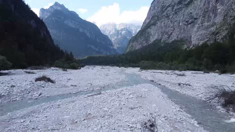 Fast-Trockener-Fluss-Mit-Majestätischem-Alpenhorizont,-Luftige-Schnelle-Fliege-In-Geringer-Höhe