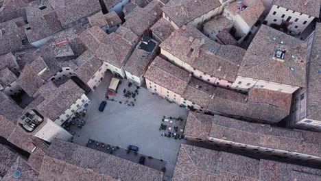 Aerial-view-of-the-roofs-of-Trevi,-its-main-square-Piazza-Mazzini-with-the-watch-tower