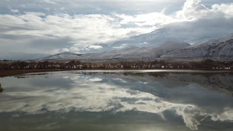 Diaz-Lake-and-Owens-Valley-on-Cloudy-Winter-Day,-California-United-States,-Wild-Nature-Lakeside-Landscape-With-Clouds-Reflection-on-Water-Surface-and-Inyo-Mountains-in-Horizon
