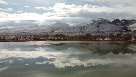 Lakeside-Landscape-of-Diaz-Lake-and-Owens-Valley-on-Cloudy-Winter-Day,-California-United-States,-Wild-Nature-With-Clouds-Reflection-on-Water-Surface-and-Inyo-Mountains-in-Horizon