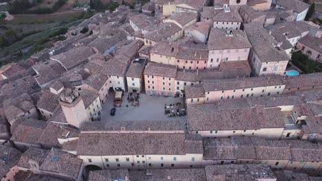 Aerial-view-of-the-roofs-of-Trevi,-its-main-square-Piazza-Mazzini-and-of-the-watch-tower