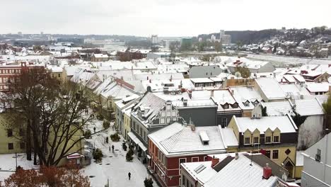 Revealing-snow-covered-rooftops-of-Kaunas-old-town,-aerial-ascend-view