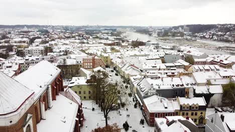 Kaunas-Cathedral-Basilica-bell-tower-and-old-town-covered-in-snow,-aerial-view
