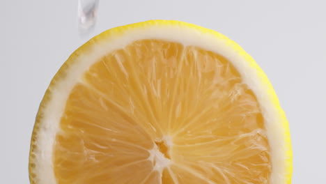 Detail-of-cut-Sicilian-lemon-with-drops-of-water-falling-on-the-piece-in-slow-motion
