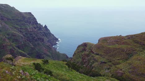 Epische-Bergklippen-Und-Küstenlinie-Enthüllen-Den-Roque-De-Taborno-Mit-Kaukasischem-Männlichem-Wandern-Auf-Teneriffa,-Kanarischen-Inseln,-Spanien---Luftaufnahme