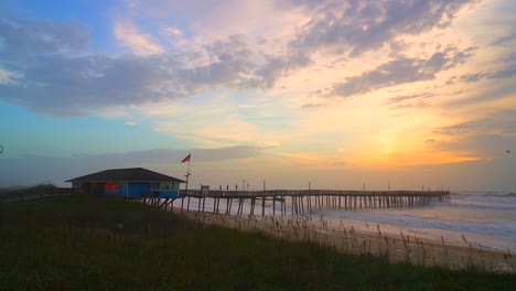 Video-of-a-majestic-and-colorful-sunrise-at-Avalon-Pier-with-an-American-flag-waving-in-the-distance