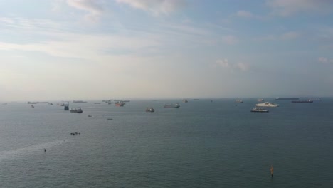 Aerial-drone-shot-of-container-ships-and-tankers-off-Singapore's-coast