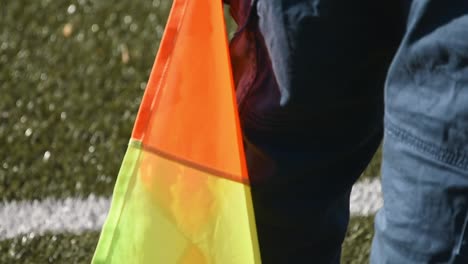 Close-up-view-of-neon-orange-and-yellow-soccer-flag-on-artificial-turf-field-in-Germany