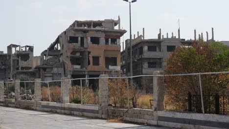 Still-shot,-ruined-buildings-behind-a-fence-in-Homs-City