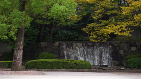 Ein-Kleiner-Künstlicher-Wasserfall,-Umgeben-Von-Vegetation-Im-Friedlichen-Ueno-Park,-Tokio