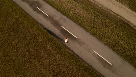 Aerial-view-of-cycling-path-and-a-slim-young-woman-running-on-it