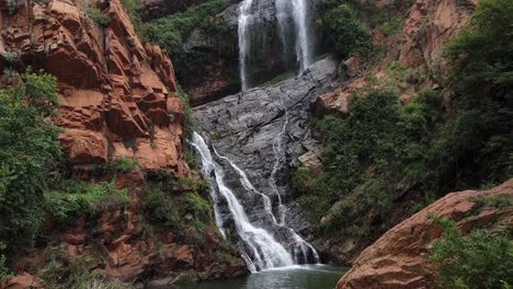 Walter-Sisulu-national-botanical-gardens-waterfall-during-spring-after-rainfall,-calm-and-relaxing-scene-with-slow-moving-panning-up-to-sky