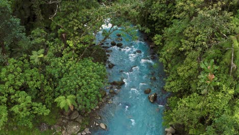 Aerial-drone-shot-of-the-famous-Rio-Celeste,-a-volcanic-river-in-the-jungle-of-Costa-Rica-with-remarkably-blue-water