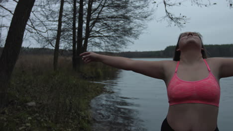 A-Woman-Wearing-Pink-Sports-bra-With-Arms-Wide-Open-While-Feeling-The-Beauty-And-Calmness-Of-Nature--Wide-Shot