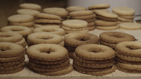 Stacks-of-linzer-cookies-lined-up-ready-for-jam,-slow-pan