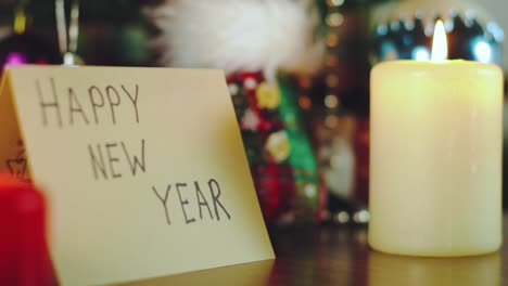 Tarjeta-De-Saludo-Que-Dice-&quot;feliz-Año-Nuevo&quot;-Con-Velas-Y-árbol-De-Navidad-Y-Decoraciones-A-Su-Alrededor