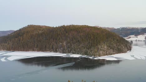 Isla-Del-Lago-Una-Gran-Colina-Con-árboles-En-Un-Lago-Congelado-En-Un-País-Del-Norte-De-Noruega