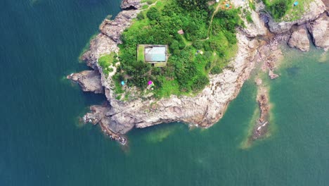 Camping-edge-of-rugged-shoreline-on-island-Tung-Lung-Chau,-aerial